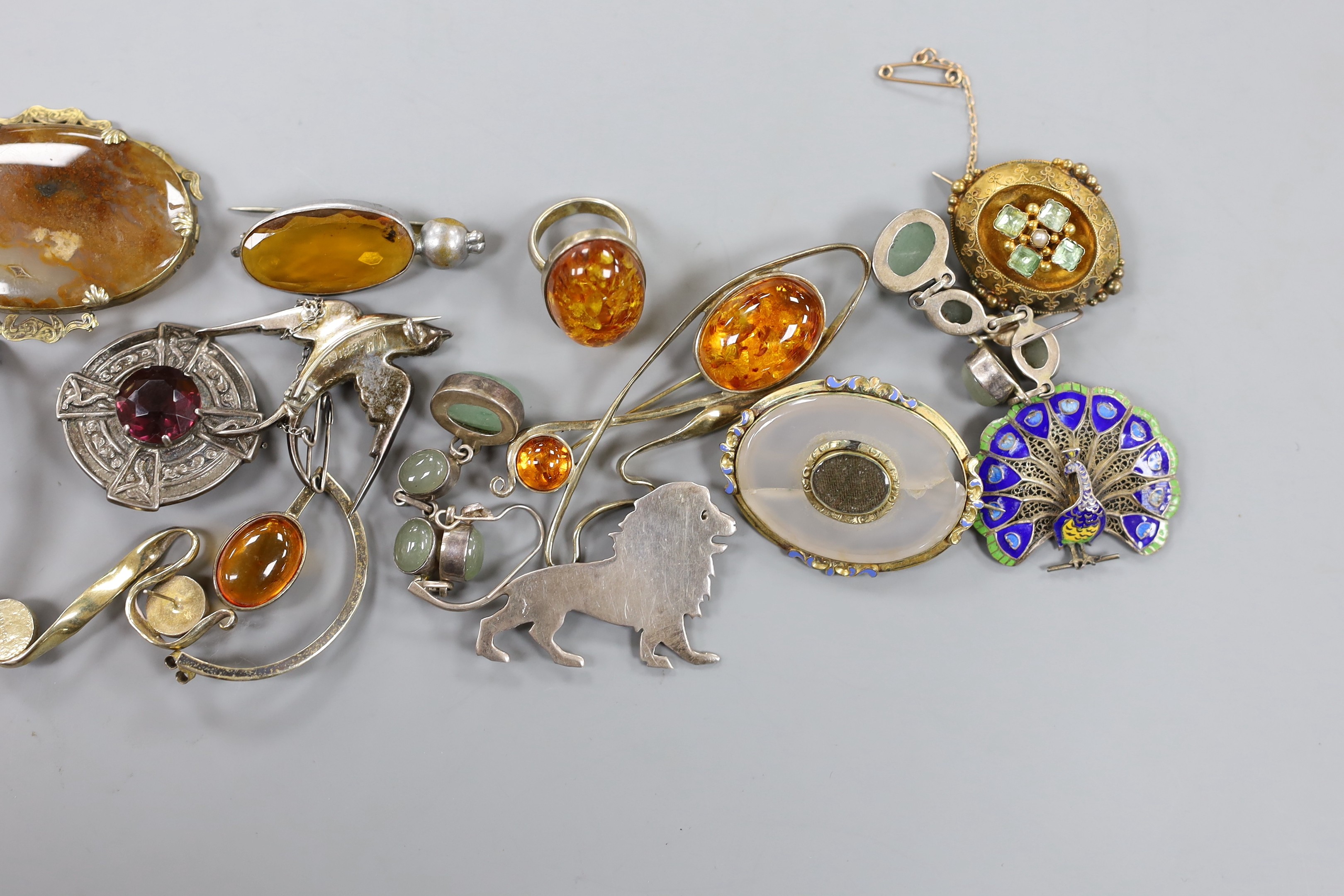 A mixed group of jewellery including a Victorian yellow metal and gem set oval brooch, a filigree white metal and enamel peacock brooch, a white metal and paste set swallow brooch, Scottish hardstone set brooch, pinchbec
